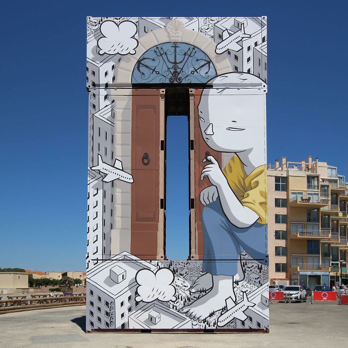Mural by Italian artist depicting a whimsical giant figure among city buildings on a large outdoor wall.
