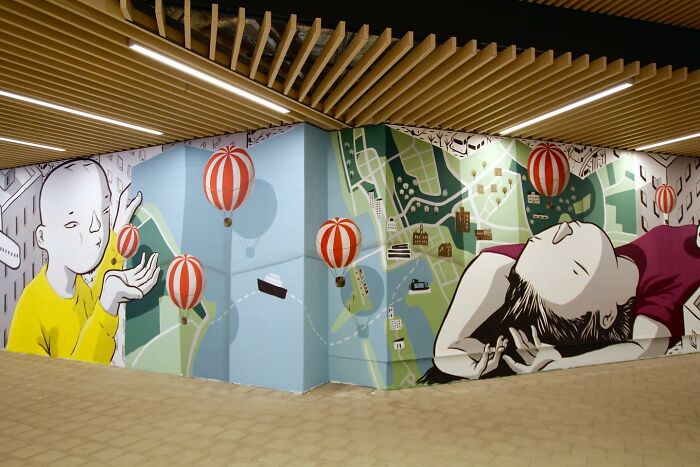 Mural by Italian artist featuring whimsical city map and floating red-striped hot air balloons on urban walls.