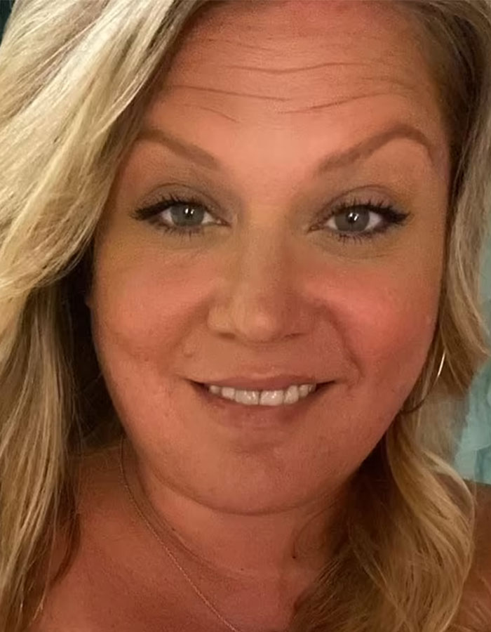 Close-up of a smiling woman with blonde hair related to road-raged woman who p**ps on car incident.