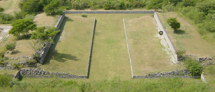 Aerial view of ancient stone ruins surrounded by greenery, showcasing bizarre historical artifacts and structures.