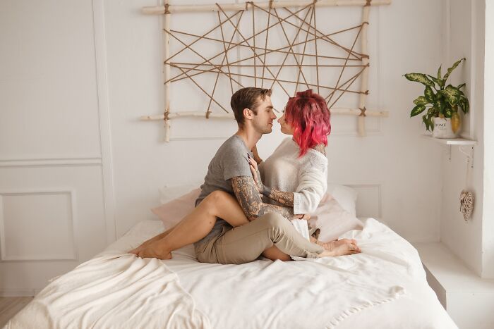Couple sitting on bed facing each other closely, illustrating people who called off their wedding and relationship struggles.