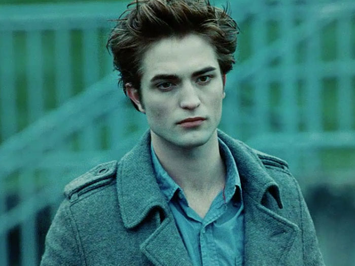 Young man with styled hair wearing a gray coat and blue shirt, representing celebrities with hygiene concerns.