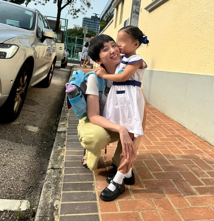 Mother comforting 4-year-old child outside preschool on a sunny day, highlighting challenging daily routines and preschool attendance. Mother comforting 4-year-old child outside preschool on a sunny day, highlighting challenging daily routines and preschool attendance.