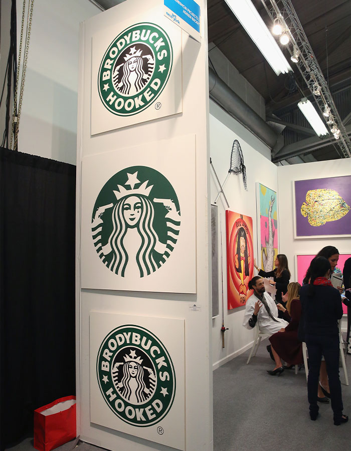 Artwork resembling Starbucks logos with the phrase Brodybucks Hooked displayed at an art exhibit. Artwork resembling Starbucks logos with the phrase Brodybucks Hooked displayed at an art exhibit.