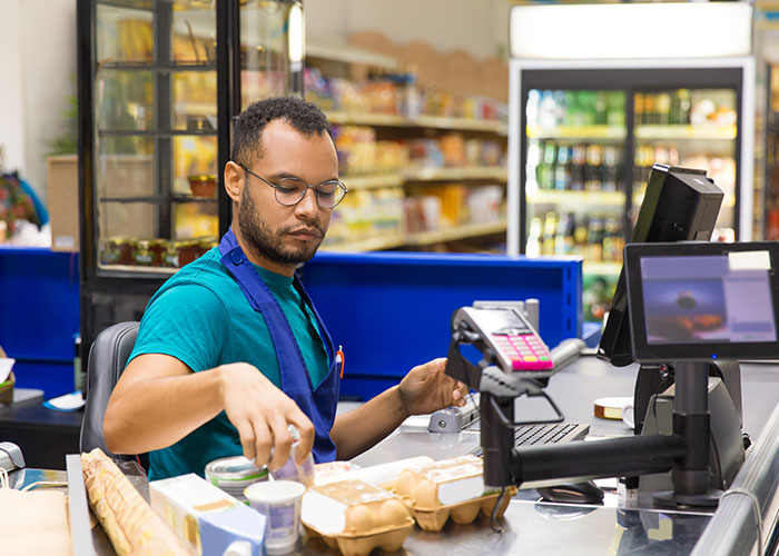 Airport employees united protesting a manager taking away their chairs in a busy airport retail checkout area.