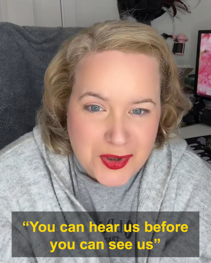 American woman in gray sweater discussing cultural differences while staying in UK with British people finding US habits rude.