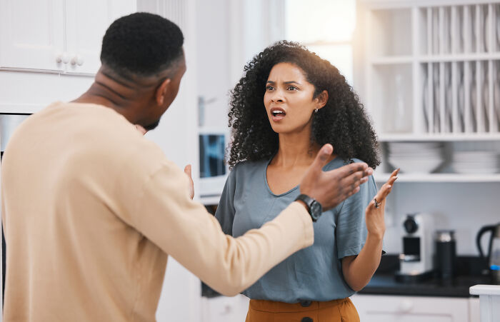 Couple having a heated argument at home, illustrating relationship issues that led to calling off their wedding.