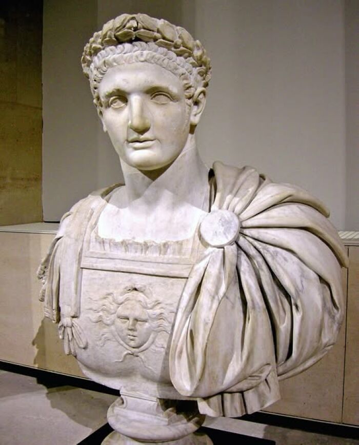 Marble bust of a Roman figure wearing detailed armor and a laurel wreath, showcasing archeology and art craftsmanship.