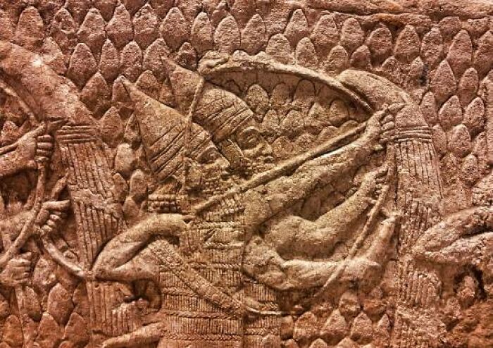 Ancient archeological art carved in stone showing warriors aiming bows, highlighting historic archeology and art craftsmanship.