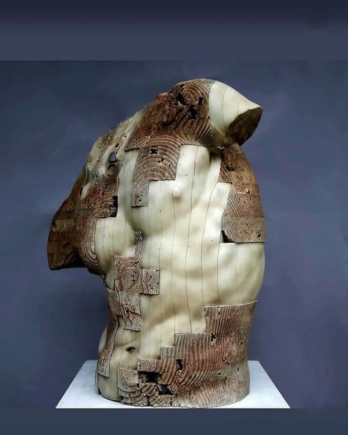 Ancient torso sculpture blending archeology and art with worn textures and smooth carved surfaces on display.