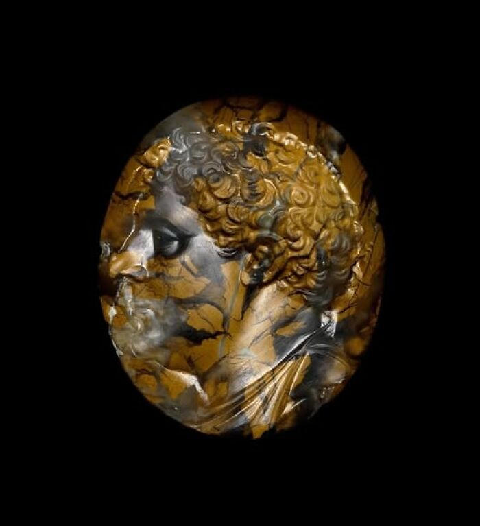 Ancient carved gemstone showcasing intricate archeology and art with a detailed profile of a bearded man in relief.