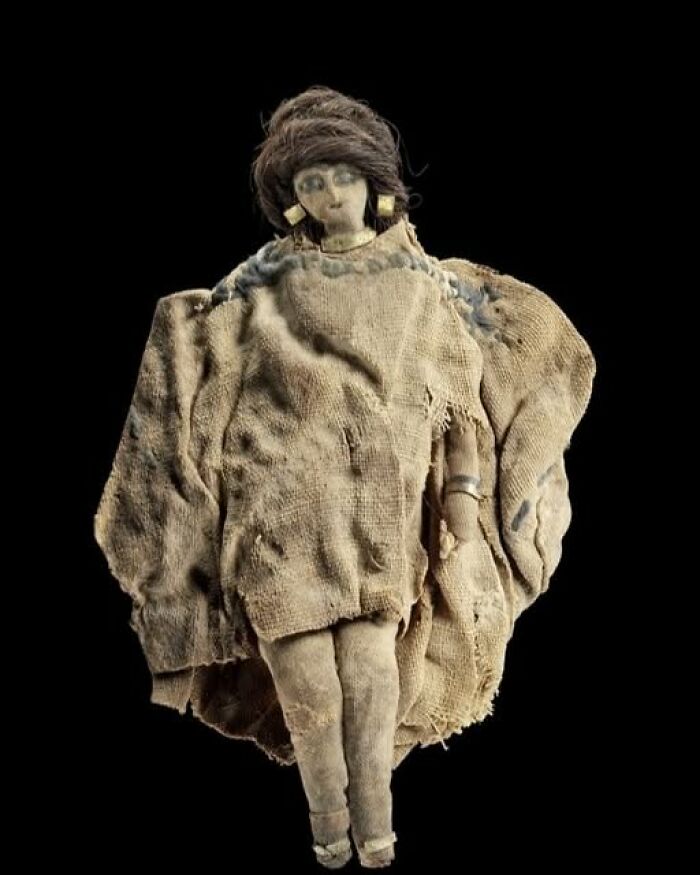 Ancient archeological art doll wrapped in worn fabric, showcasing historical craftsmanship and cultural significance.