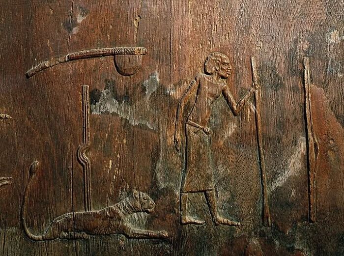 Ancient wooden carving showing a human figure and animal, representing archeological wonders in art and history.