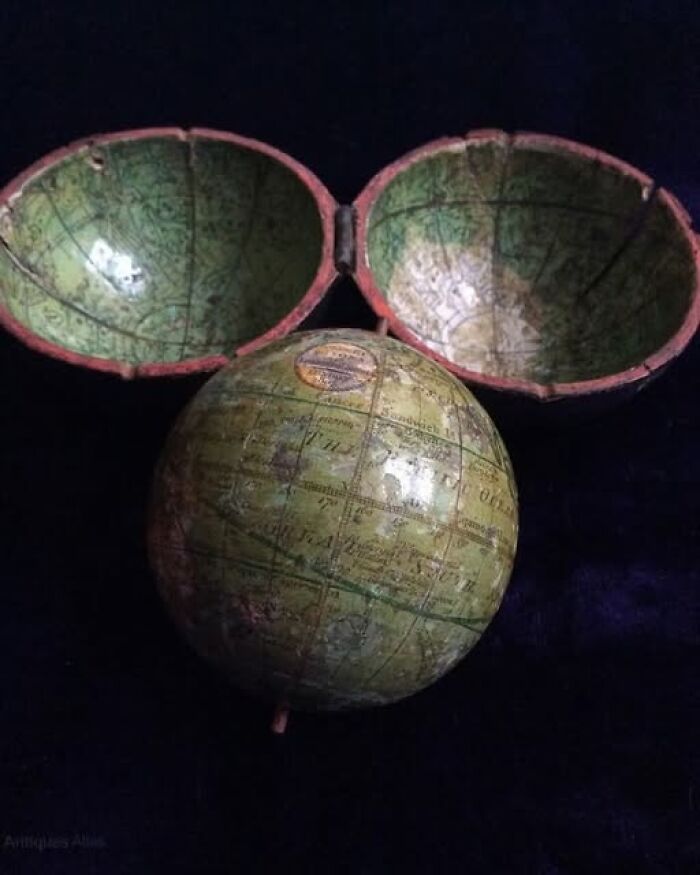 Ancient archeological art showcasing a vintage globe with a split outer shell revealing detailed maps inside.