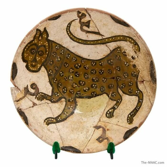 Ancient ceramic plate featuring a spotted feline design, showcasing archeology and art from historical discoveries.