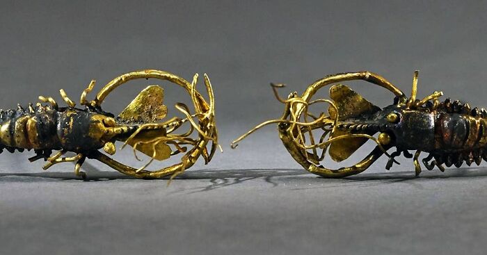 Intricate golden arthropod-shaped artifacts displayed side by side, showcasing archeology and art in ancient craftsmanship.