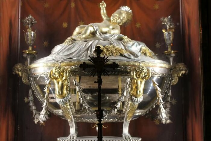 Ornate archeological art artifact featuring gold and silver sculpture with intricate detailing on display.