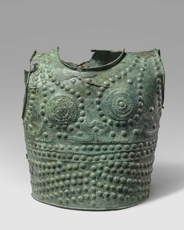 Ancient bronze armor with intricate decorative patterns, an archeological wonder showcasing historic art and craftsmanship.