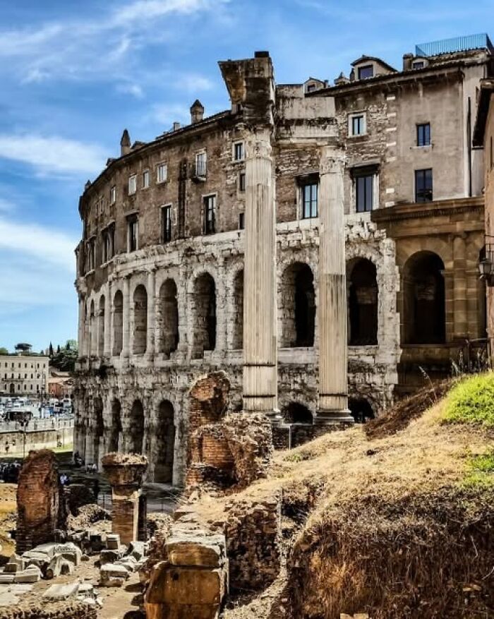 Ancient archeological wonder featuring historic stone columns and ruins under a bright blue sky in an urban setting.