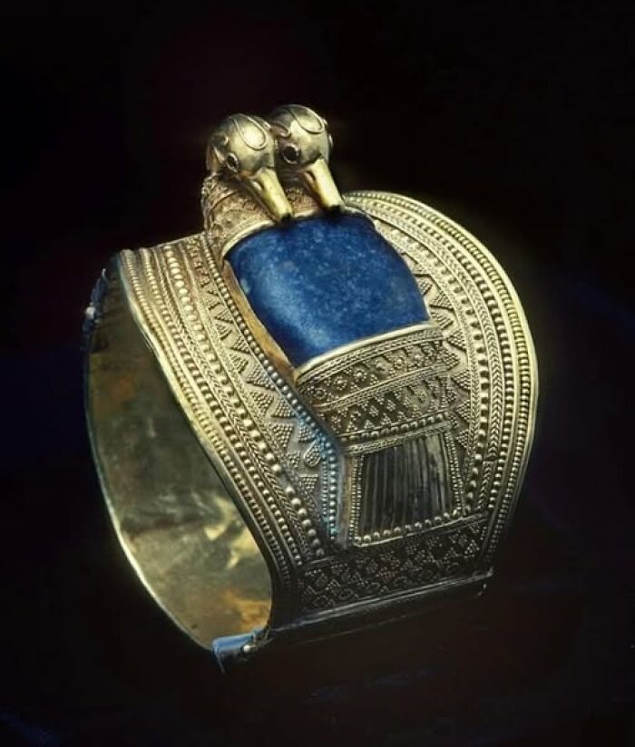 Ancient archeology and art bracelet with intricate gold detailing and blue stone, showcasing archeological wonders.