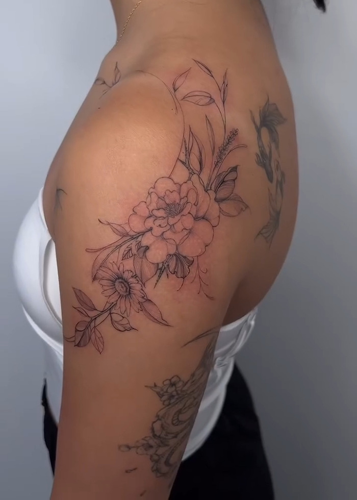 Floral tattoo design on upper arm and shoulder, highlighting the tattoo boom and trends in 2025.