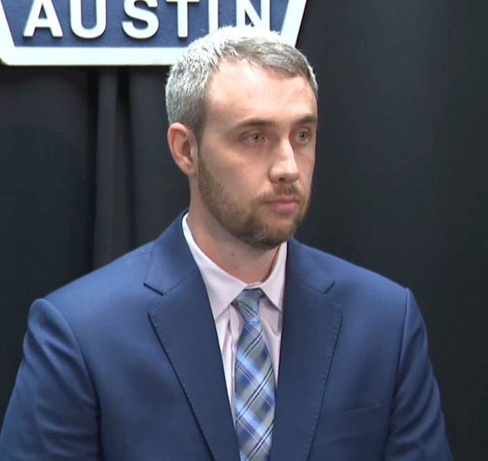 Man in blue suit and plaid tie speaking at a press conference about a mom who locked 7YO child in closet case.