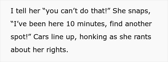 Woman standing in parking spot to save it for her husband, causing a scene as cars honk and line up behind her.