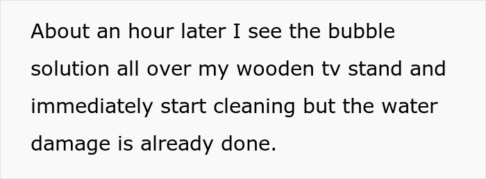 Close-up of text describing water damage on a wooden TV stand caused by a bubble solution spill.