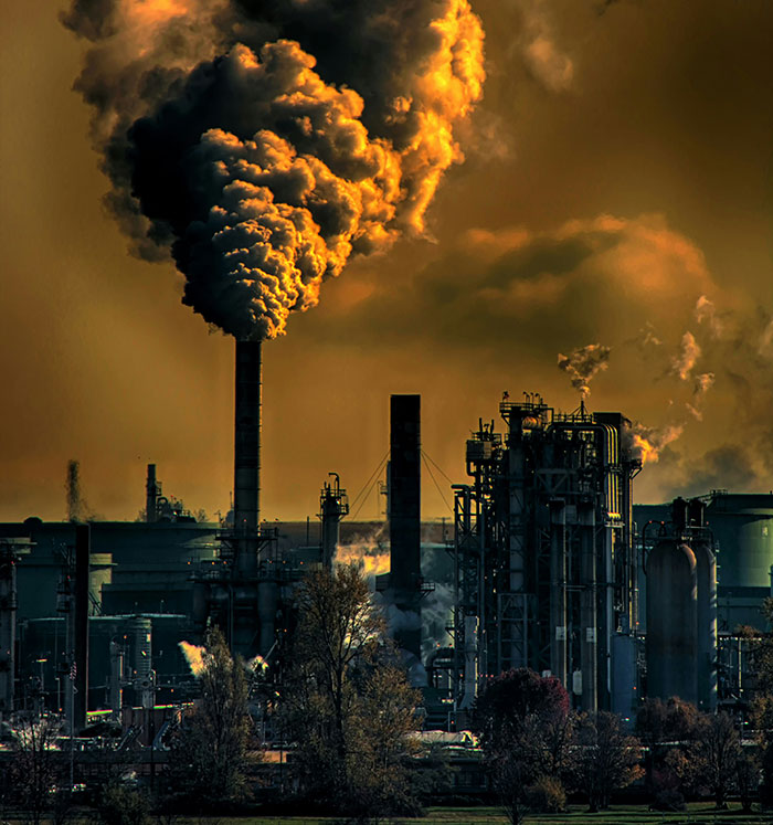 Industrial factory emitting thick smoke into the sky, highlighting the biggest elephant in the room pollution issue.