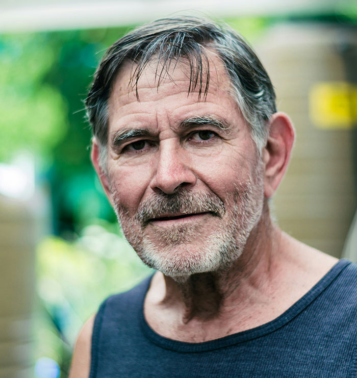 Close-up portrait of an older man with gray hair and beard, showing a massive awkward truth overlooked by everyone.
