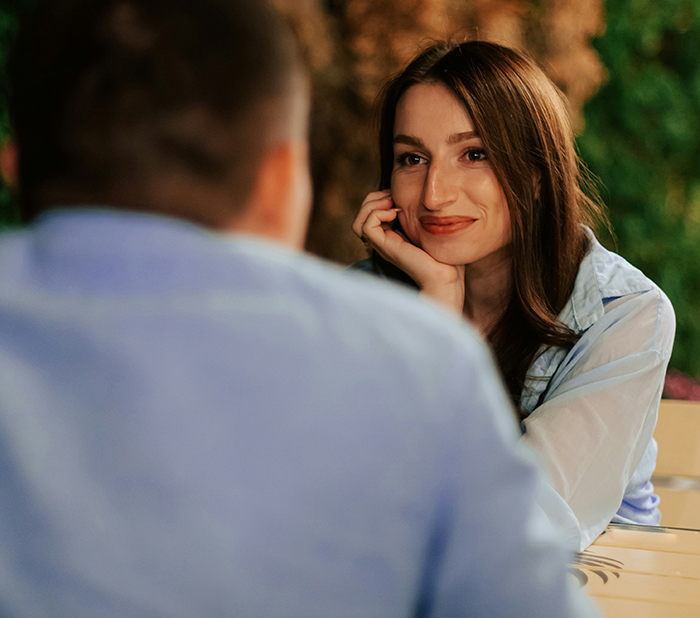 Young woman smiling and listening attentively during a conversation about the biggest elephant or blue whale in the room.
