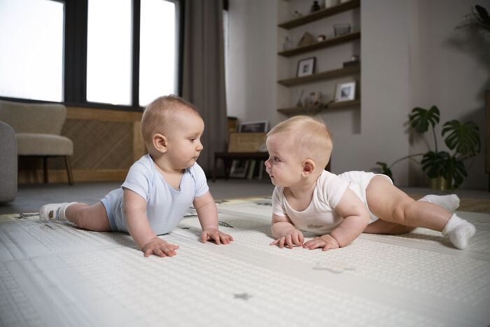 Two babies lying on a play mat indoors, illustrating hilariously bad names that had people questioning parenting choices.