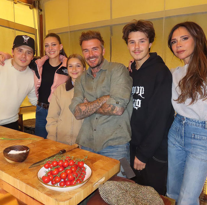 Victoria Beckham with family in a casual kitchen setting amid wedding rumors involving Nicola Peltz and her son's event.