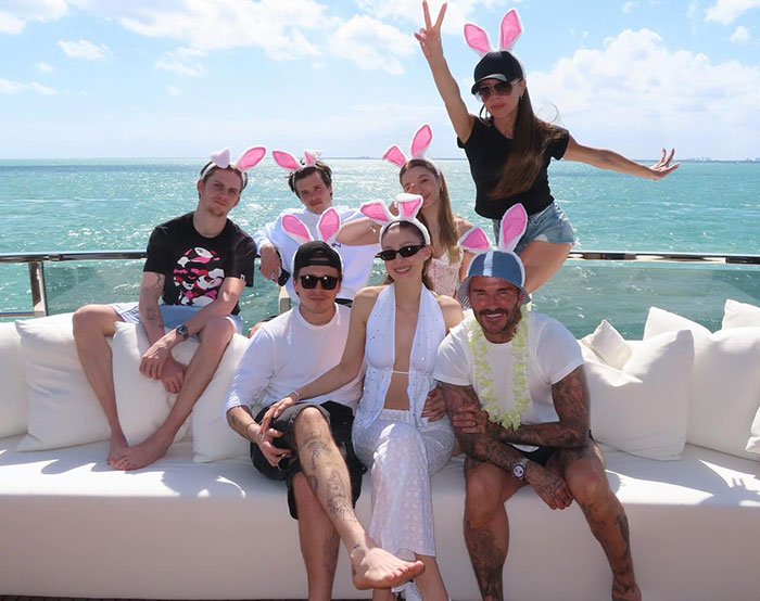 Group of people wearing bunny ears relaxing outdoors by the sea, related to Brooklyn Beckham's ex breaking silence on Beckham family.