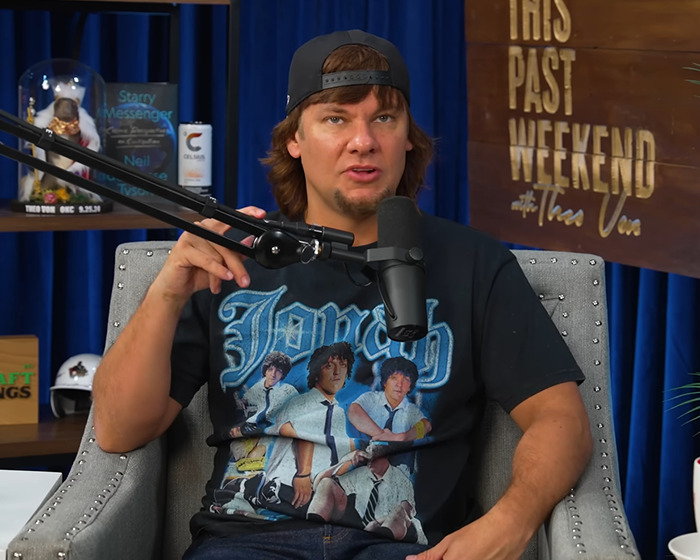 Man speaking into a microphone during a podcast episode, discussing Ben Shapiro dragged after slamming Taylor Swift. Man speaking into a microphone during a podcast episode, discussing Ben Shapiro dragged after slamming Taylor Swift.