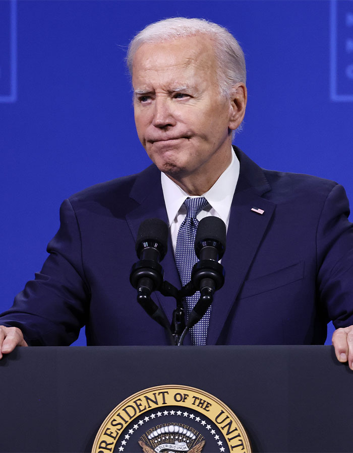 Former President Biden at a podium, addressing the public on health amid aggressive prostate cancer with reported bone spread.