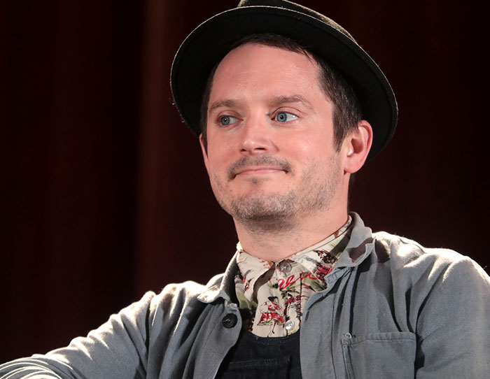 Man wearing a hat and patterned shirt sharing stories about the strangest ways people have crossed paths with celebs.