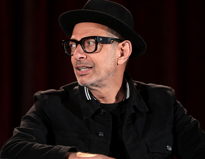 Man in black hat and glasses sharing stories about the strangest ways people have crossed paths with celebs.