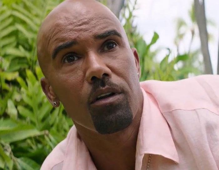 Man with shaved head and goatee wearing pink shirt outdoors, illustrating strange ways people cross paths with celebs.