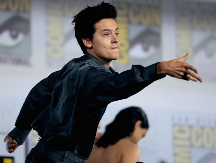 Young male celebrity extending his arm on stage at a Comic-Con event, one of the strangest ways people crossed paths with celebs