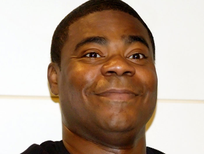 Close-up of a man smiling, illustrating stories about the strangest ways people have crossed paths with celebs.