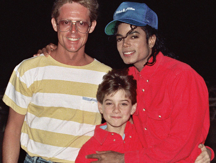 Man and boy posing with Michael Jackson at night, showcasing one of the strangest ways people have crossed paths with celebs.