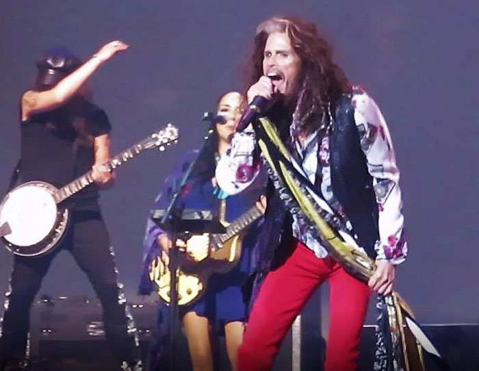 Rock band performing live on stage, capturing the strange ways people have crossed paths with celebs.