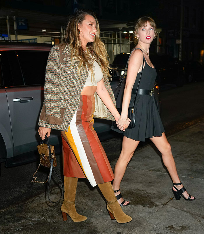 Blake Lively and Taylor Swift holding hands walking at night, linked in alleged blackmail feud with personal texts.