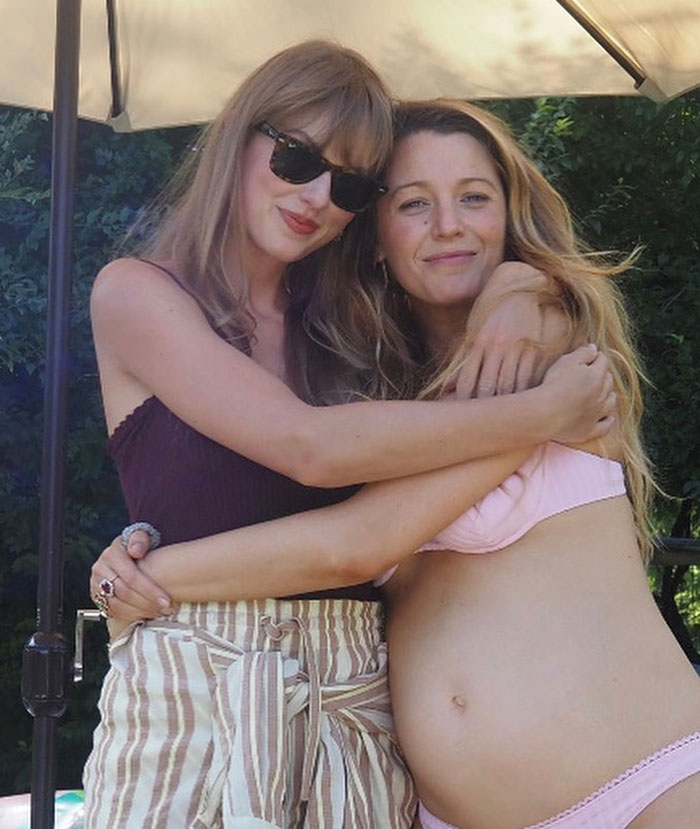 Blake Lively and Taylor Swift hugging outdoors with sunglasses and casual summer outfits in a friendly moment together
