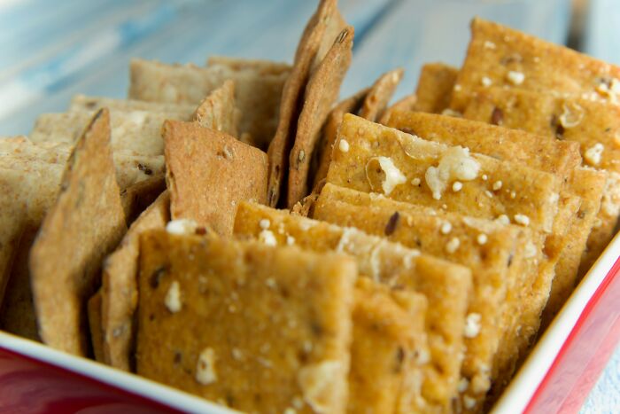 Close-up of assorted crackers in a red dish, showcasing the weird and hilarious things found secretly by girlfriends.