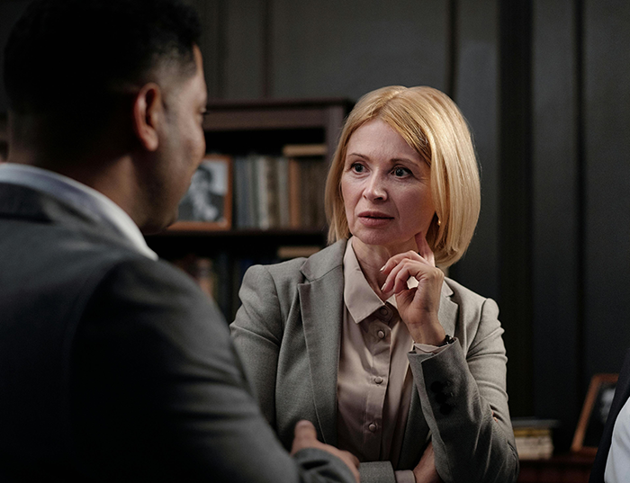 Boss and employee in a serious office discussion, highlighting workplace bullying and playing it by the book negotiation.