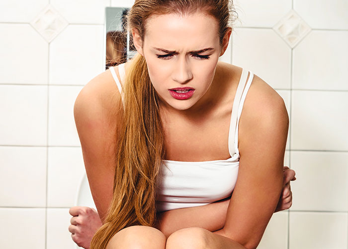 Young woman showing discomfort sitting on toilet, relating to period pad and tissues refusal issue in relationship. Young woman showing discomfort sitting on toilet, relating to period pad and tissues refusal issue in relationship.