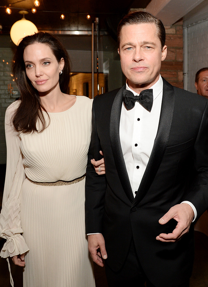 Brad Pitt wearing a tuxedo with Angelina Jolie in a cream dress at an indoor event highlighting divorce battle updates.