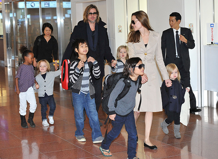 Brad Pitt and Angelina Jolie with children at airport amid divorce battle developments.